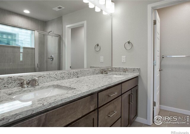 bathroom featuring tile patterned flooring, vanity, and walk in shower