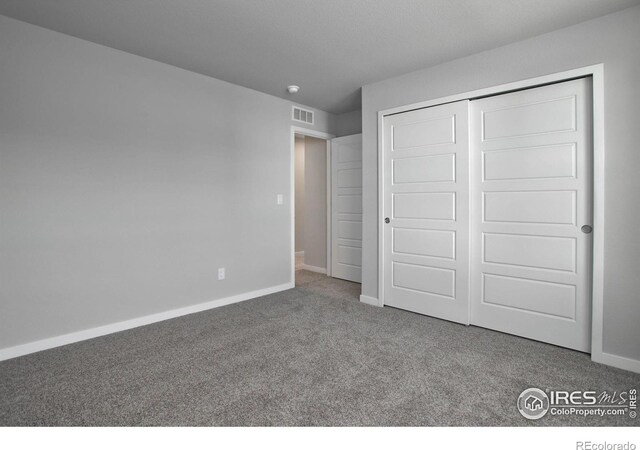 unfurnished bedroom with carpet and a closet