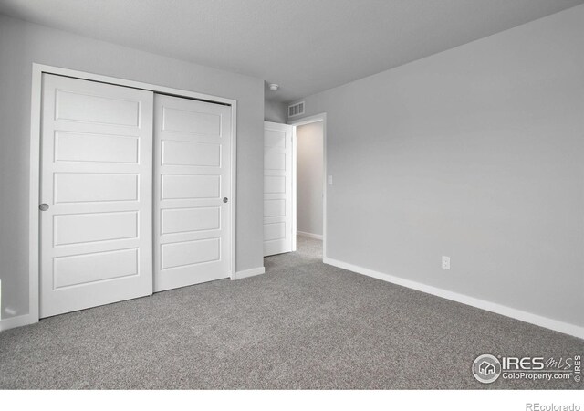 unfurnished bedroom with a closet and carpet floors