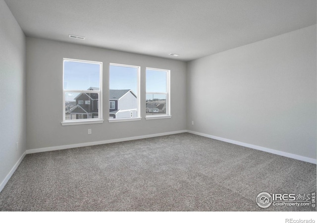 carpeted spare room featuring a textured ceiling