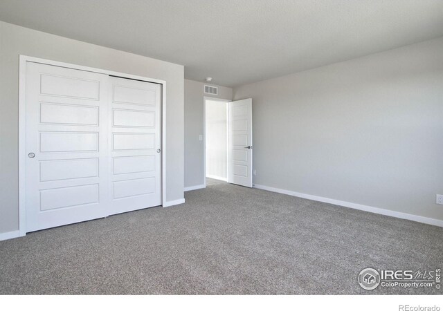 unfurnished bedroom featuring carpet flooring and a closet