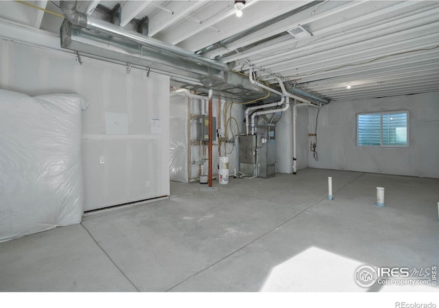 basement featuring electric panel and heating unit