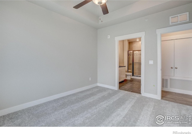 265 High Point Dr Unit 203, Longmont, CO 80504 - unfurnished bedroom with carpet flooring, baseboards, ensuite bathroom, and a raised ceiling