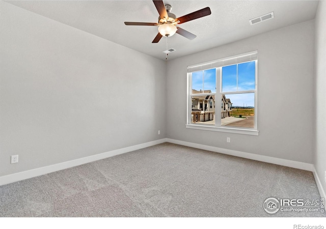 carpeted spare room featuring ceiling fan