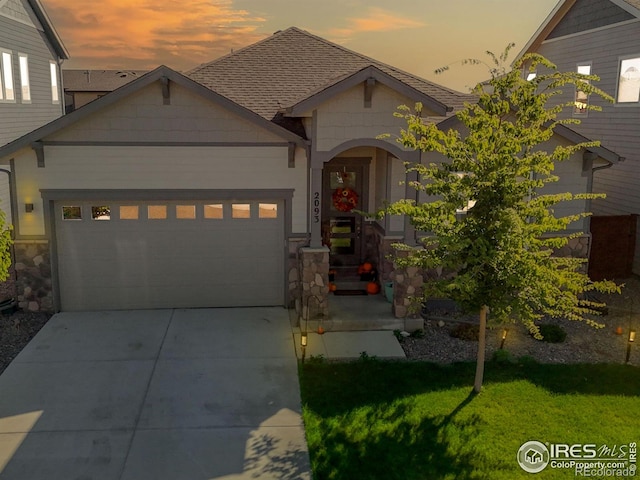 view of front of home with a garage and a lawn