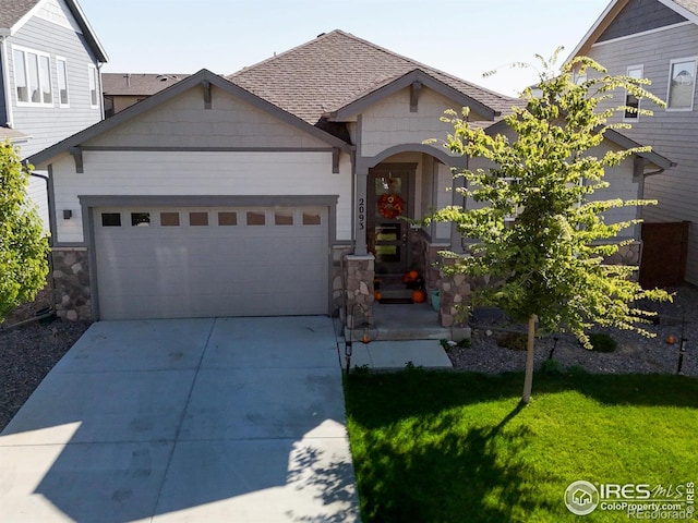 view of front of property with a shingled roof, a front yard, a garage, stone siding, and driveway