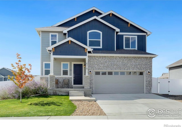 craftsman house with a front yard and a garage