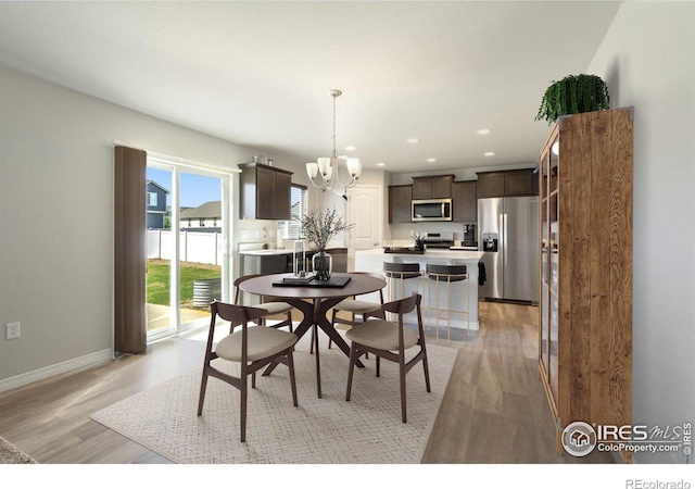 dining room with a notable chandelier and light hardwood / wood-style flooring