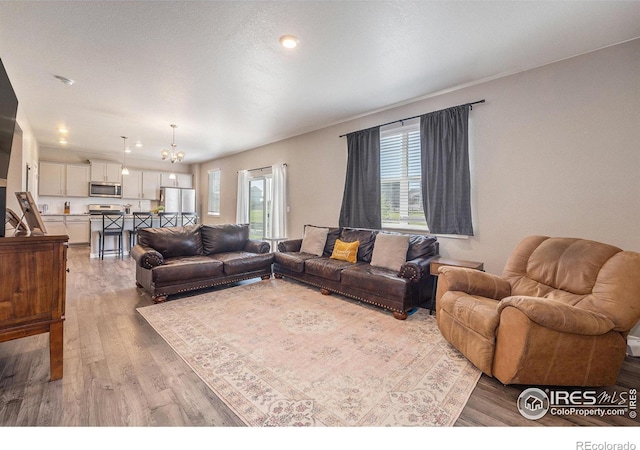 living room with a notable chandelier and wood-type flooring