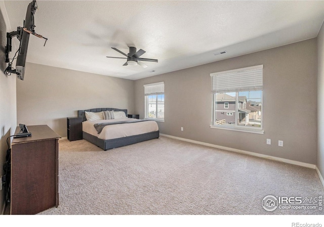 bedroom featuring a textured ceiling, light carpet, and ceiling fan