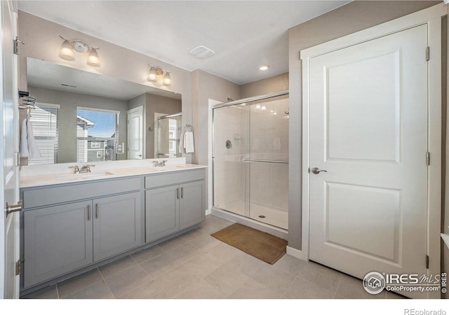 bathroom with tile patterned flooring, an enclosed shower, and vanity