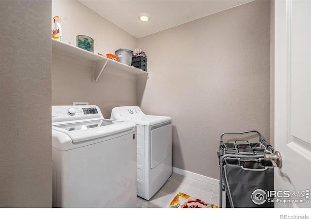 laundry room featuring washer and clothes dryer and light tile patterned floors