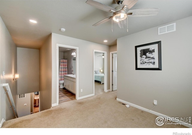 carpeted bedroom with ceiling fan and ensuite bathroom