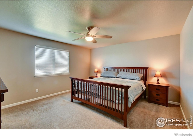 carpeted bedroom featuring ceiling fan and a textured ceiling