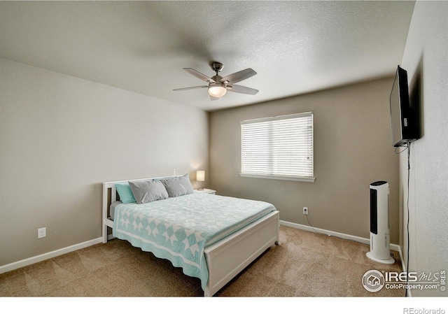 carpeted bedroom with ceiling fan and a textured ceiling