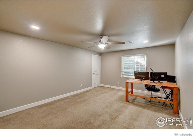 carpeted home office featuring a textured ceiling and ceiling fan