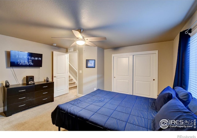 carpeted bedroom featuring a closet, ceiling fan, and a textured ceiling