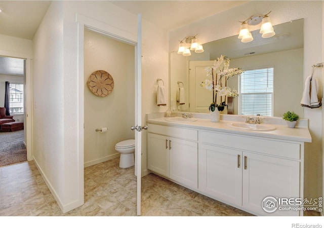 bathroom with vanity, toilet, and plenty of natural light