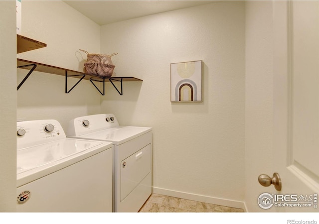 laundry area with light tile patterned flooring and washer and dryer