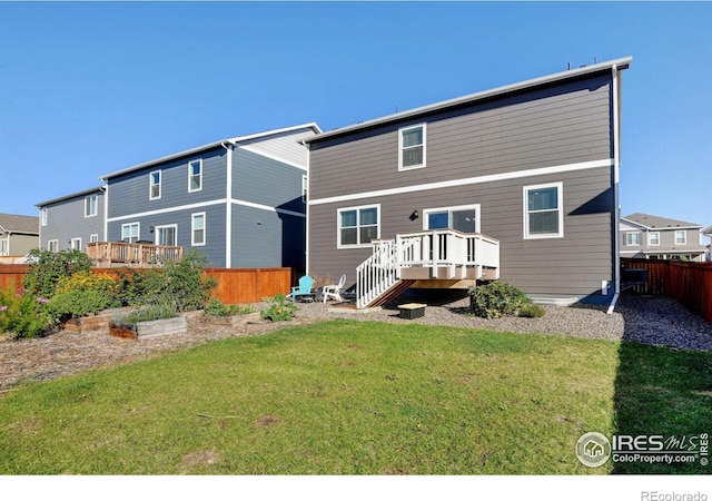 rear view of house with a yard and a wooden deck