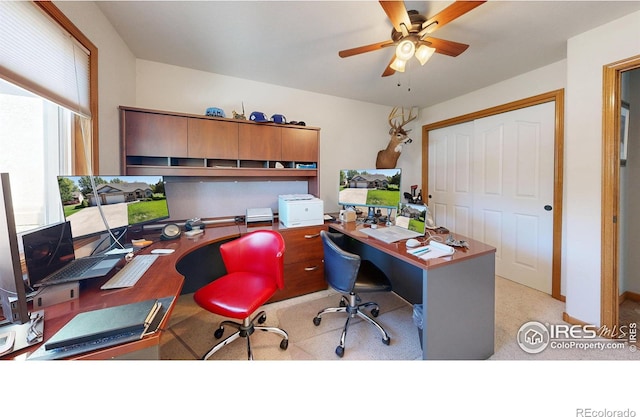 home office featuring light carpet and ceiling fan