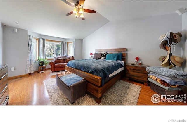 bedroom with ceiling fan, light hardwood / wood-style flooring, and vaulted ceiling