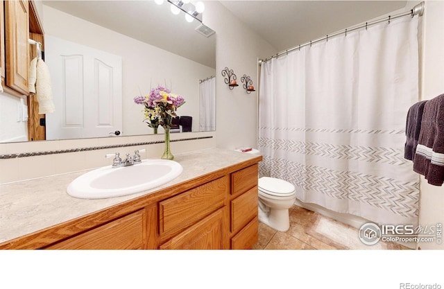 bathroom featuring tile patterned flooring, vanity, and toilet