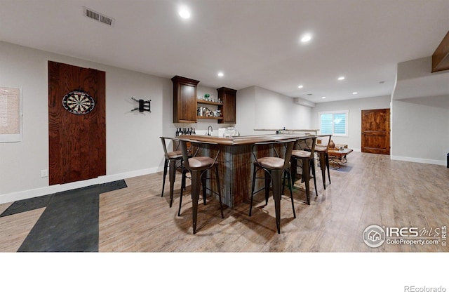 kitchen with a kitchen breakfast bar and light hardwood / wood-style flooring