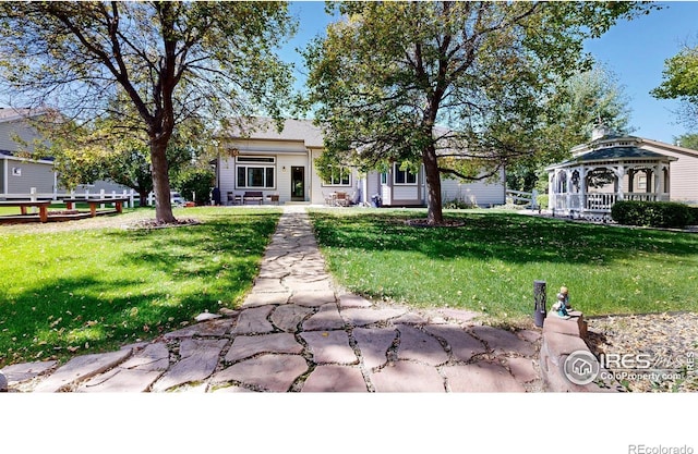 rear view of property with a gazebo and a yard