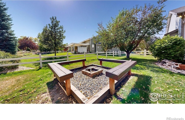 view of home's community with a lawn and an outdoor fire pit