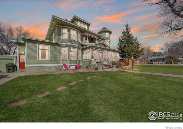 victorian house with a yard and a patio area