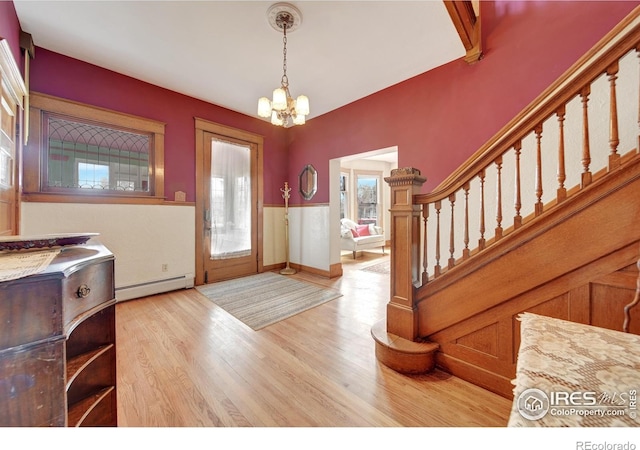 foyer entrance featuring light hardwood / wood-style flooring, a chandelier, and baseboard heating