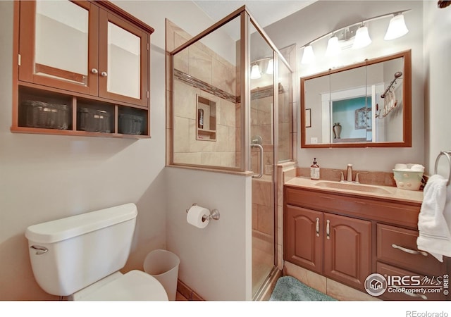 bathroom with a shower with door, toilet, and vanity