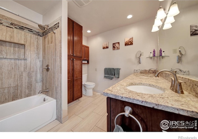 full bathroom featuring tiled shower / bath combo, vanity, and toilet