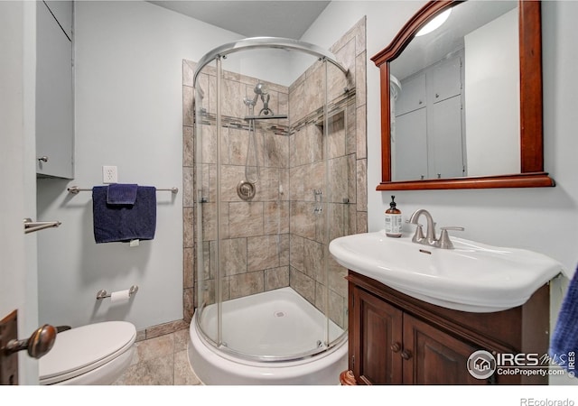 bathroom featuring vanity, tile patterned flooring, toilet, and a shower with door