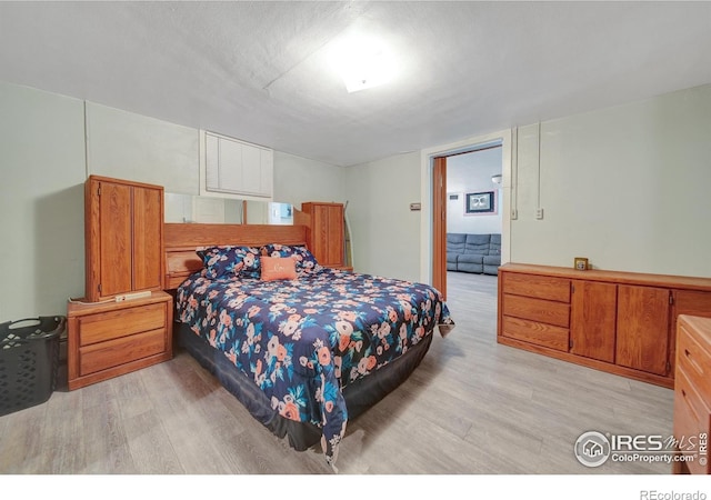 bedroom featuring light hardwood / wood-style floors and a textured ceiling