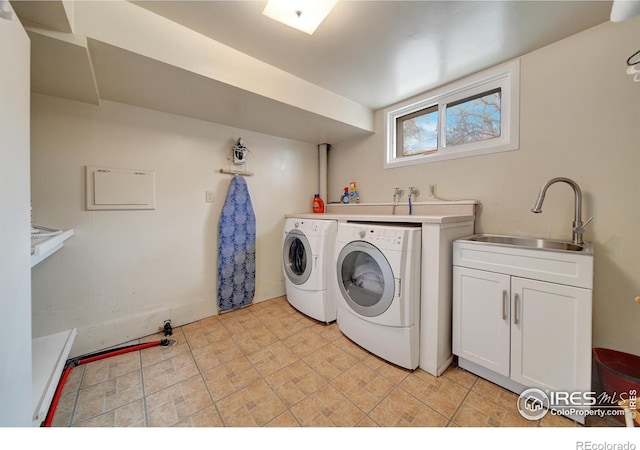 laundry room featuring sink, independent washer and dryer, and cabinets