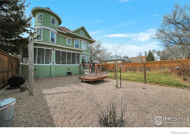 rear view of property featuring a sunroom and a wooden deck