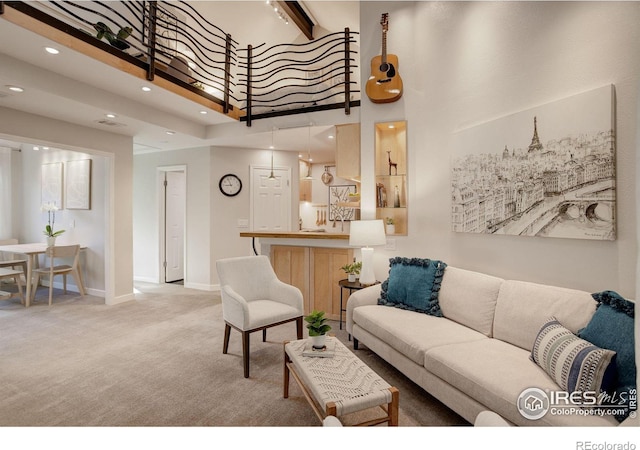 carpeted living room with a towering ceiling