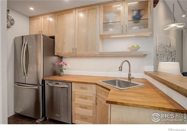 kitchen with light brown cabinetry, appliances with stainless steel finishes, sink, and wooden counters