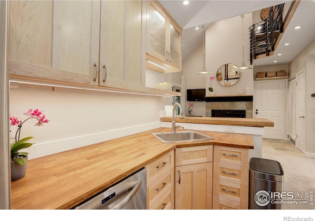 kitchen with dishwasher, butcher block countertops, sink, and light brown cabinets