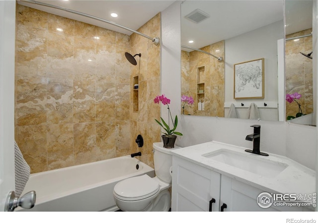 full bathroom featuring tiled shower / bath, vanity, and toilet