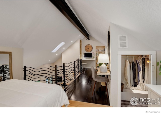 bedroom featuring hardwood / wood-style flooring, vaulted ceiling with skylight, and a closet