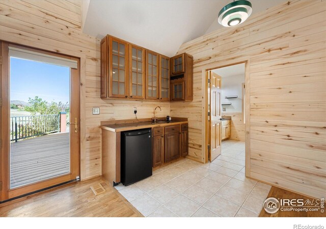 kitchen featuring refrigerator and wooden walls