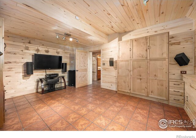 unfurnished living room with wooden ceiling, tile patterned floors, and wooden walls