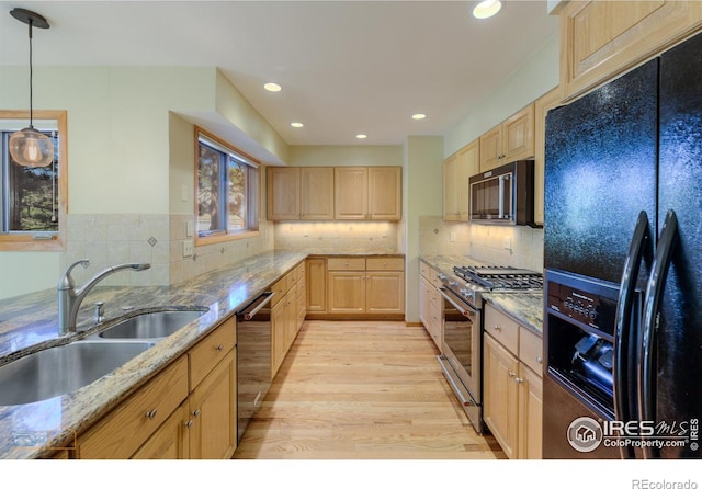 kitchen featuring light wood-type flooring, sink, black appliances, light brown cabinets, and light stone countertops