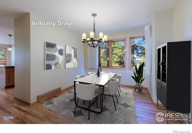 dining room featuring an inviting chandelier, light hardwood / wood-style flooring, and a wealth of natural light