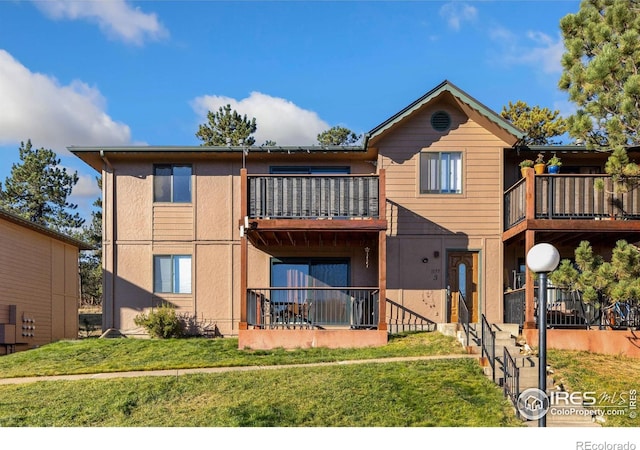 exterior space featuring a balcony and a yard