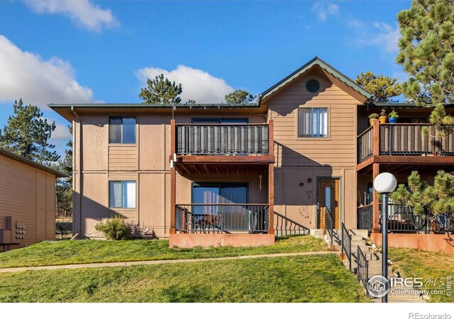 1155 S Saint Vrain Ave Unit U6, Estes Park, CO 80517 - back of house featuring a balcony, a lawn, and stucco siding