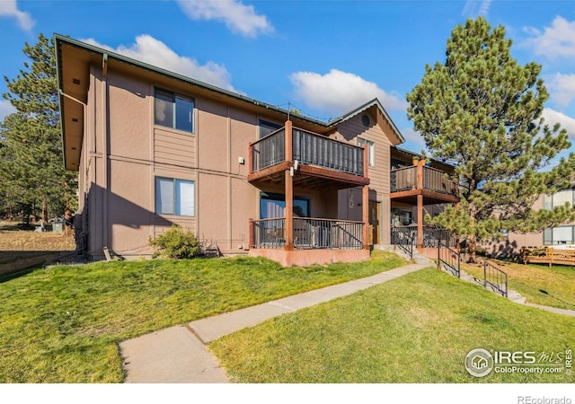 back of property featuring a lawn and a balcony